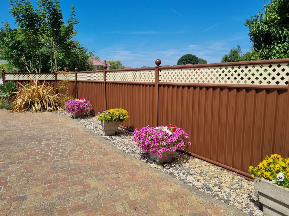 Flower beds by brown fence