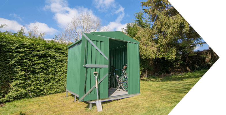 Green shed in grassy area

